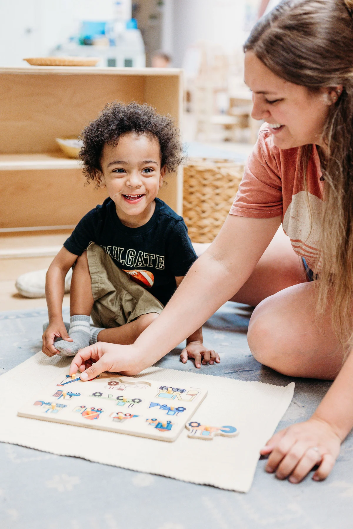 A guide and a smiling child working together on a puzzle
