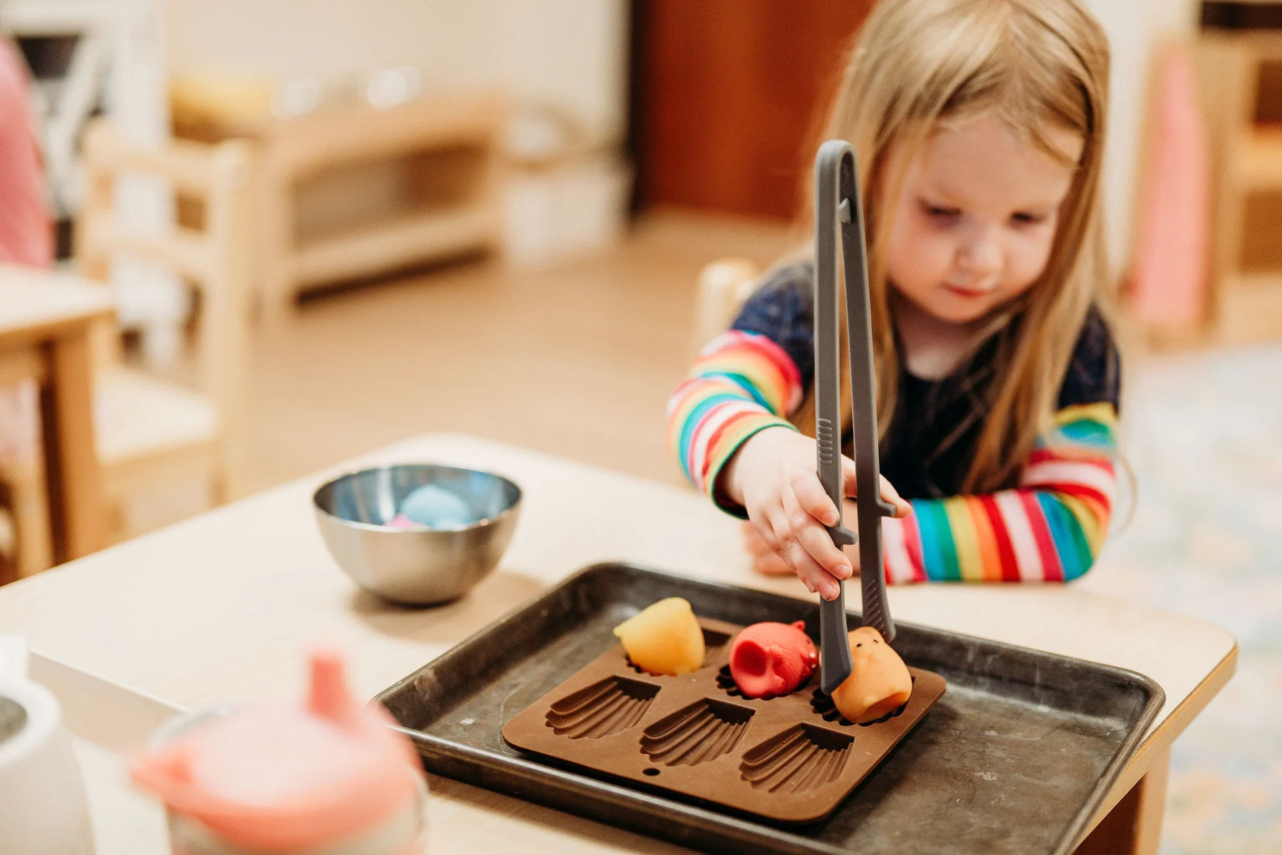 A child practicing a hands-on Montessori activity at Kindred Hill