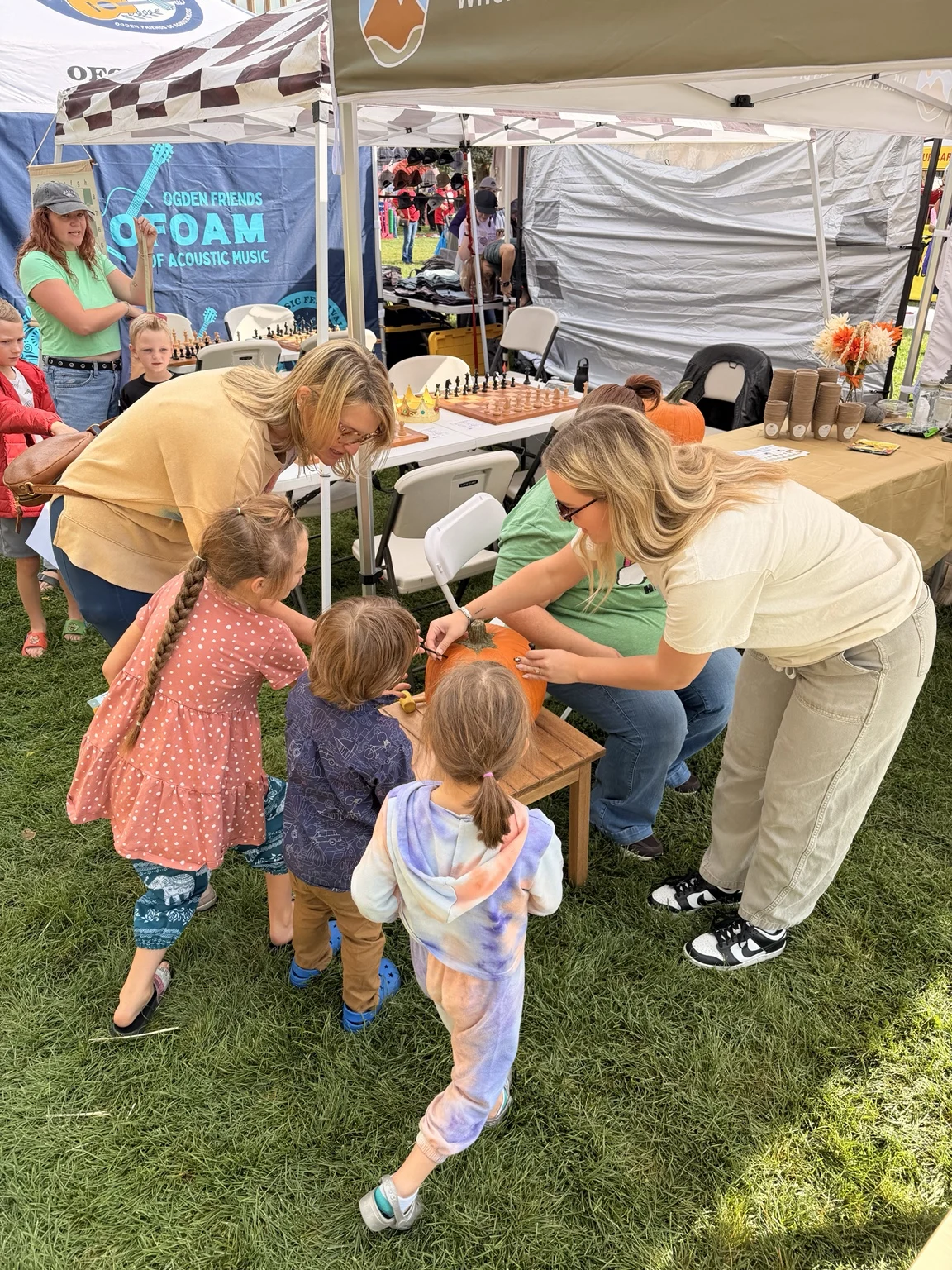 Adults helping children with an activity at the Kindred Hill festival booth