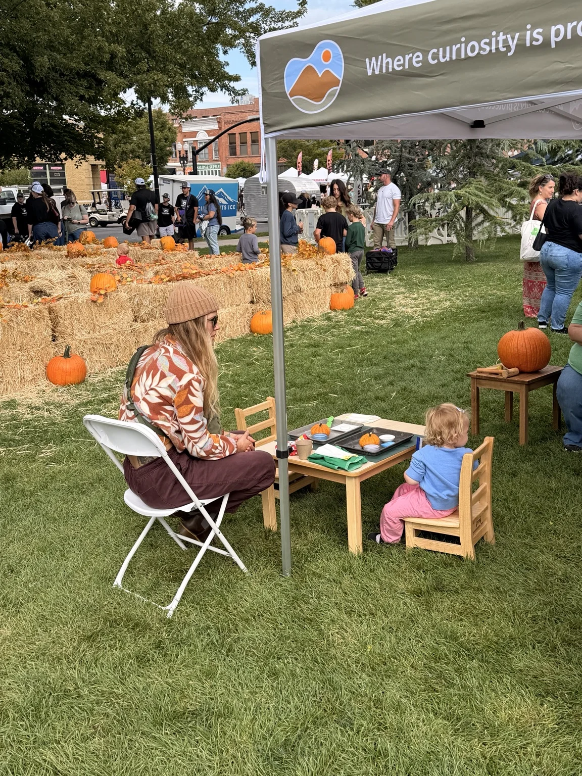 A child exploring materials at a small table under the Kindred Hill tent